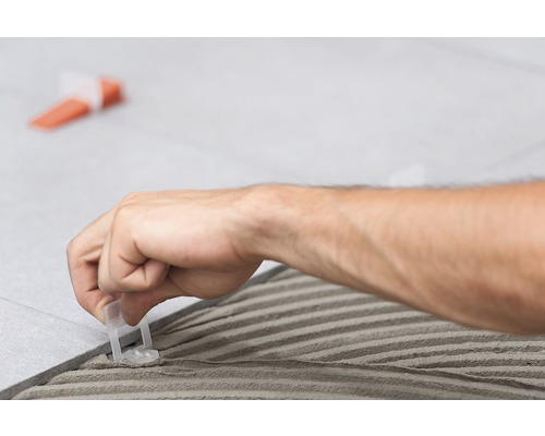 Obkladač používá nivelační systém pro pokládku dlaždic