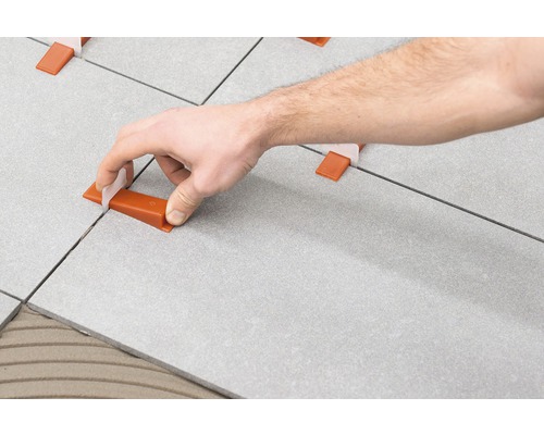 Obkladač používá nivelační systém pro rovnoměrný vzor obkladů