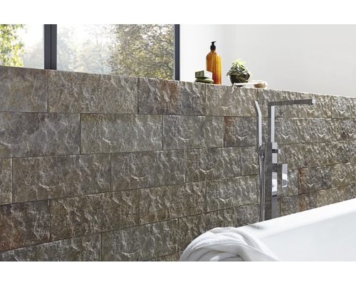 Design koupelny s obkladem z přírodního kamene, vanou a armaturami