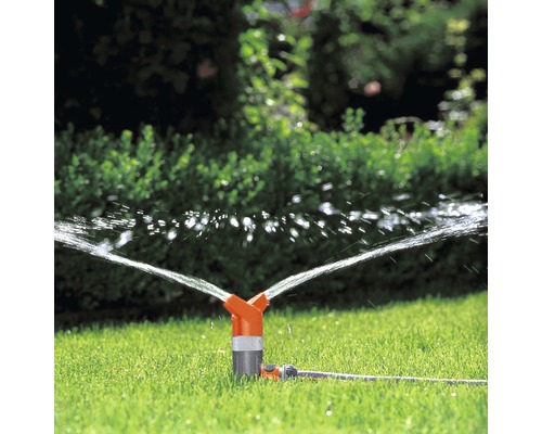 Zavlažovač trávníku zavlažuje trávník v zahradě