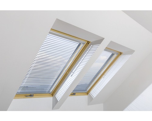 Dvě střešní okna se žaluziemi v světlé místnosti.