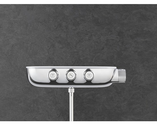 Nástěnný sprchový panel se třemi regulátory pro ovládání různých sprchových funkcí.