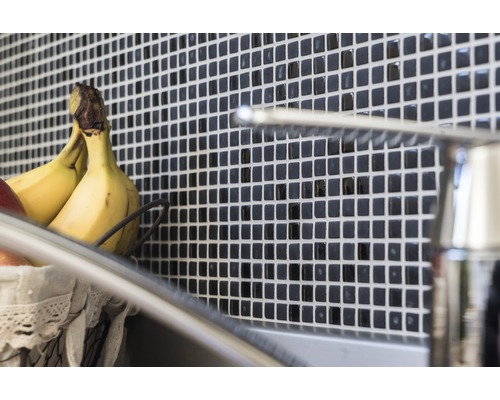 Obkládačky s mozaikovým vzorem za umyvadlem s vodovodní baterií a košíkem na ovoce