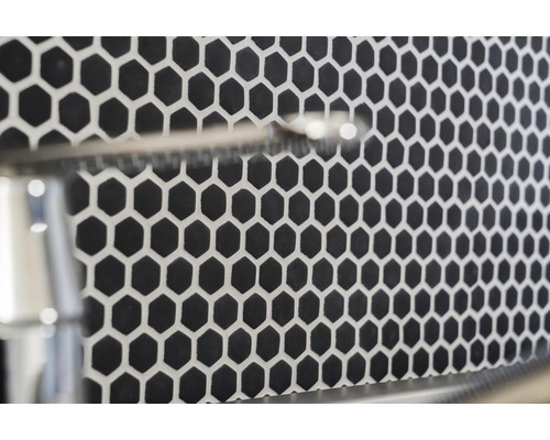 Detailní záběr černých šestiúhelníkových dlaždic se světlými spárami