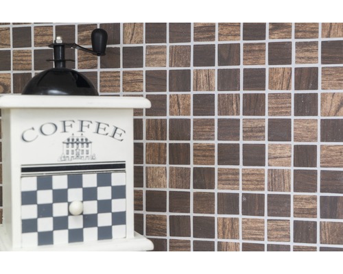 Dekorativní mlýnek na kávu na mozaikovém pozadí