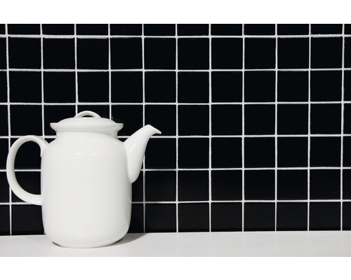 Keramická čajová konvice před čtvercovým vzorem dlaždic