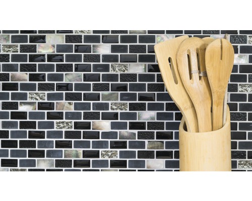 Dřevěné kuchyňské náčiní v nádobě před mozaikovou stěnou