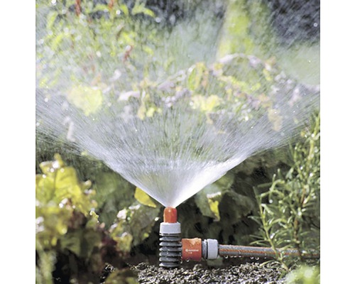 Zahradní scéna s běžícím obdélníkovým zavlažovačem pro zavlažování zahrady