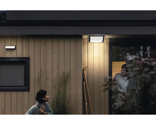 Venkovní pohled na dům s osvětlením a dvěma lidmi