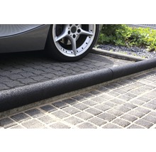 Vozidlo s gumovým omezovačem parkovacího místa na dlažebních kostkách