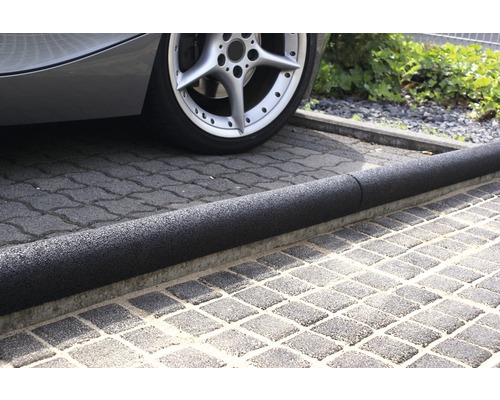 Vozidlo s gumovým omezovačem parkovacího místa na dlažebních kostkách