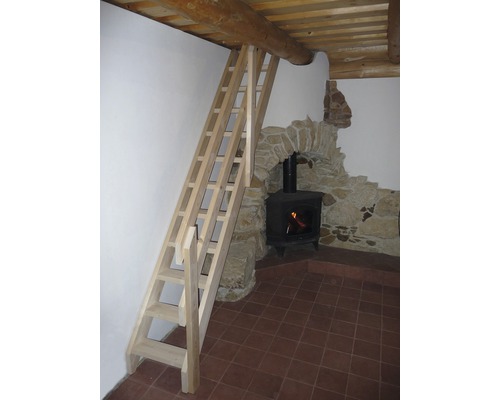 Dřevěné schodiště vedoucí k dřevěnému trámovému stropu vedle krbu