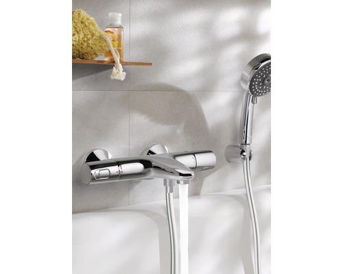Nástěnná vanová baterie s ruční sprchovou soupravou na okraji vany