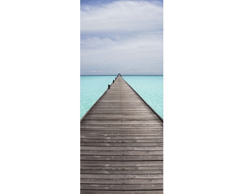 Dřevěná lávka nad tyrkysovou vodou pod jasnou oblohou.