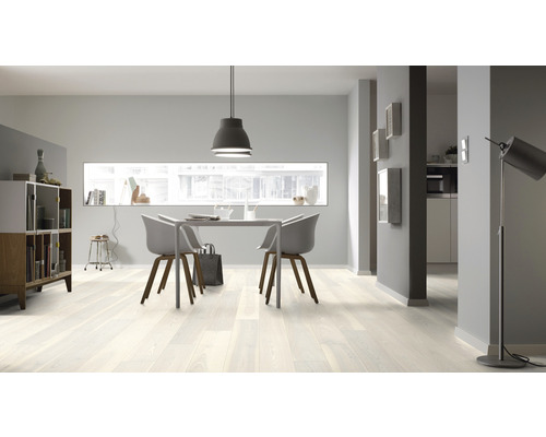 Světlý obývací pokoj s dřevěnou podlahou, jídelním stolem a židlemi.