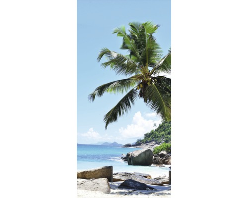 Tropická plážová scéna s kameny, palmami a modrou oblohou