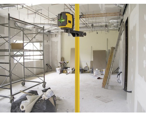 Místnost v hrubé stavbě s čárovým laserem na teleskopické tyči