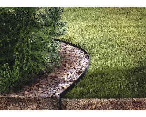 Kovový obrubník odděluje trávník a mulčovací kůru pod stromem