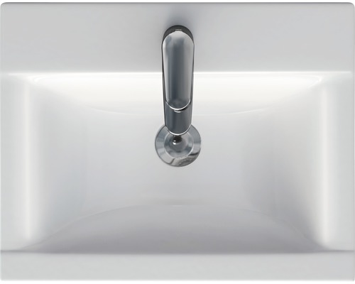 Pohled shora na bílé umyvadlo s vodovodní baterií