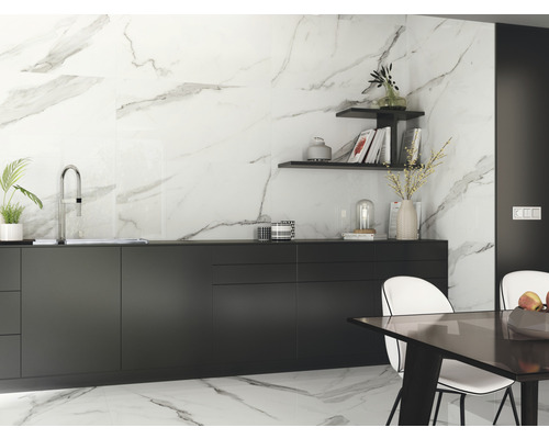 Světlá kuchyně s mramorovými dlaždicemi, černými skříněmi a jídelním stolem