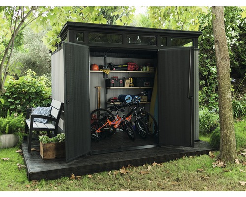 Zahradní domek s otevřenými dveřmi, interiér s policemi, jízdními koly a zahradním nářadím