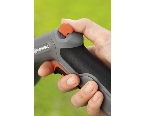 Ruka ovládá zahradní stříkací pistoli značky Gardena.