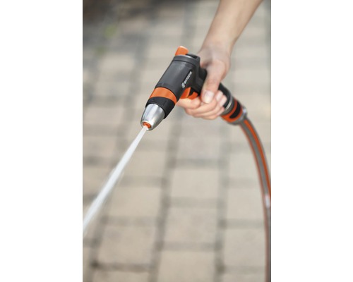 Čisticí postřikovač Gardena s vodním paprskem v ruce