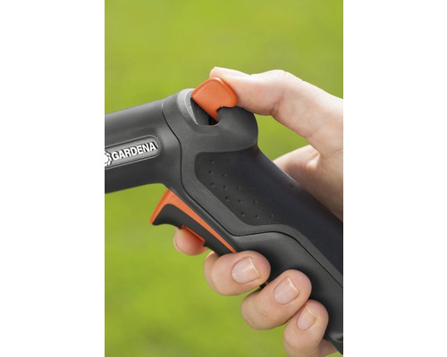 Detailní pohled na ruku ovládající zahradní hadici s logem Gardena