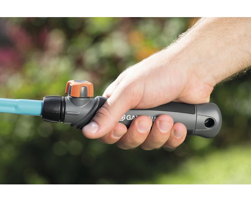 Ruka drží zahradní hadici Gardena s uzavíracím ventilem.