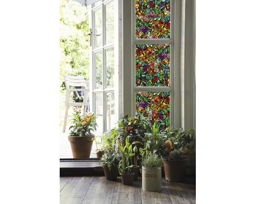 Dekorační fólie s rostlinným vzorem na oknech, obklopená hrnkovými rostlinami a otevřenými dveřmi