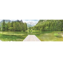 Panoramatický výhled na horské jezero s dřevěným molem, obklopené stromy a horami.