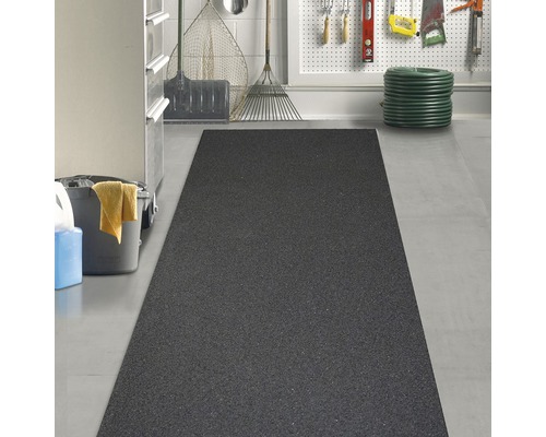 Černá gumová rohož v garáži se zahradním nářadím