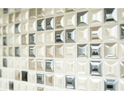 Detailní pohled na stěnu se čtvercovými mozaikovými dlaždicemi.