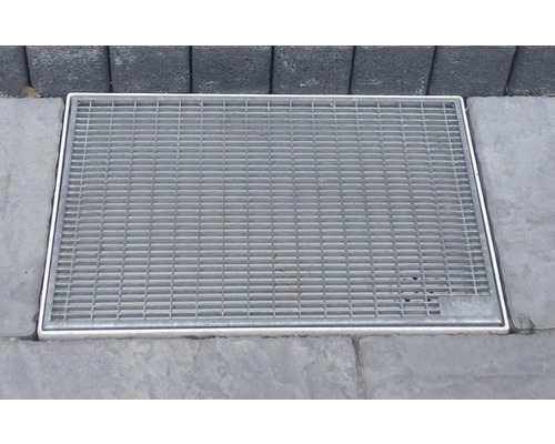 Pohled shora na obdélníkový dvorní vpust s mříží