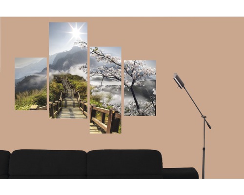 Vícedílný nástěnný obraz s horskou krajinou a třešňovými květy nad pohovkou a stojací lampou