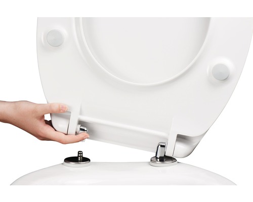 Ruka montuje záchodové prkénko