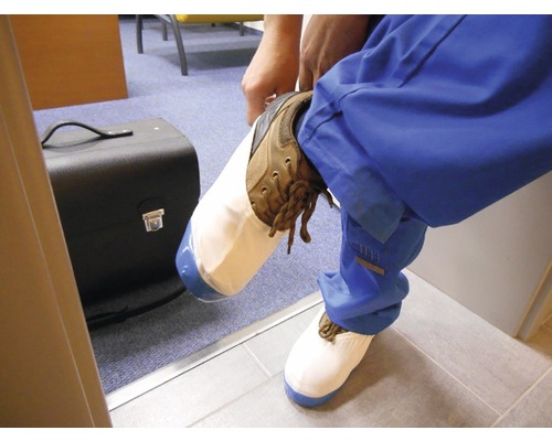 Muž si navléká návleky na boty