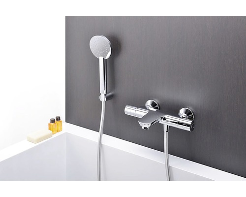 Nástěnná sprchová baterie s ruční sprchou na šedé stěně