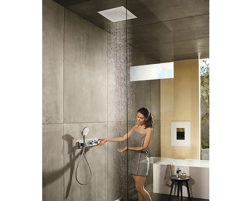 Moderní sprcha se čtvercovou sprchovou hlavicí, sprchovým termostatem a ženou s ručníkem