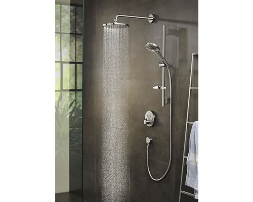 Sprchový systém s horní sprchou, ruční sprchou a termostatickou baterií v koupelnovém prostředí.