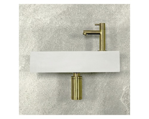 Baterie a sifon namontované na umyvadle před stěnou