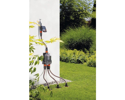 Automatický zahradní zavlažovací systém s zavlažovacím počítačem a několika zavlažovacími tryskami na trávníku