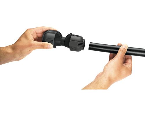 Montáž černé PE trubkové spojky dvěma rukama.