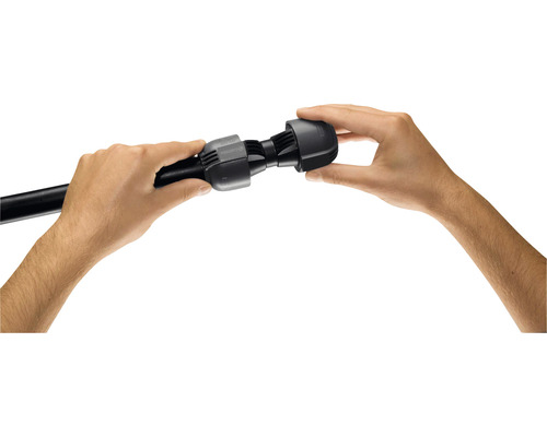 Dvě ruce montují černý konektor na černou trubku.