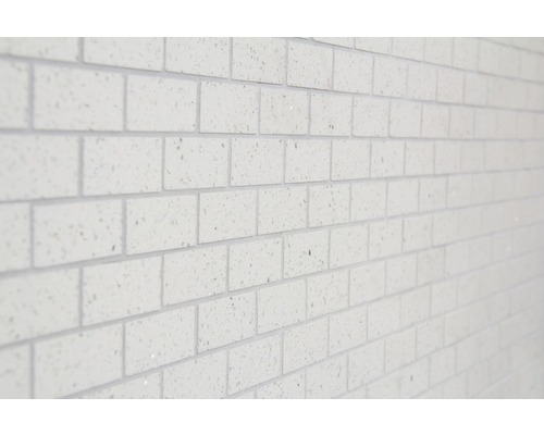 Detail stěny s bílými obkladovými cihlami