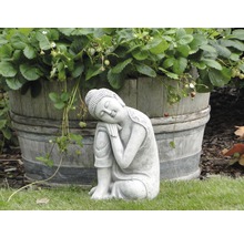 Kamenná soška Buddhy vedle dřevěného sudu s jahodníky