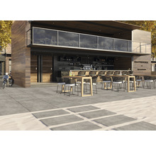 Venkovní posezení restaurace se stoly, židlemi a kamennými deskami
