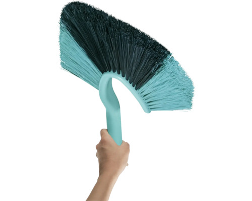 Ruka drží stropní kartáč s plastovými štětinami