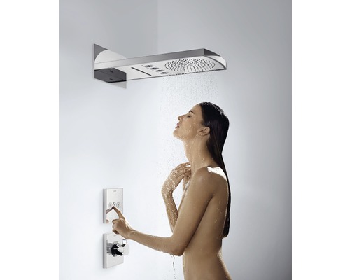 Žena pod sprchovou hlavicí s ovládacími prvky