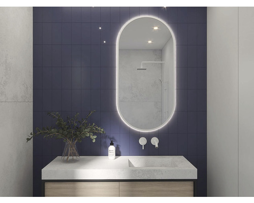 Koupelna s umyvadlem, zrcadlem s osvětlením a modrou obkládačkou